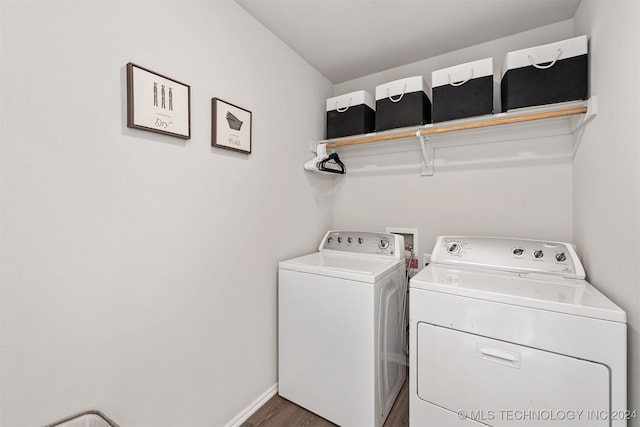 clothes washing area with washer and dryer and wood-type flooring