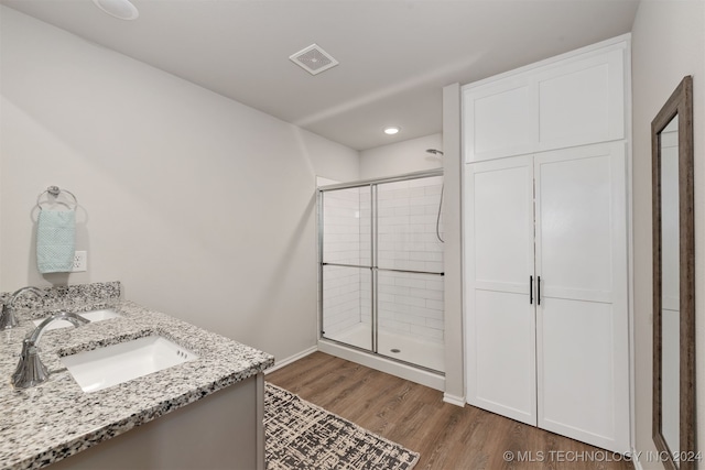 bathroom with vanity, an enclosed shower, and wood-type flooring