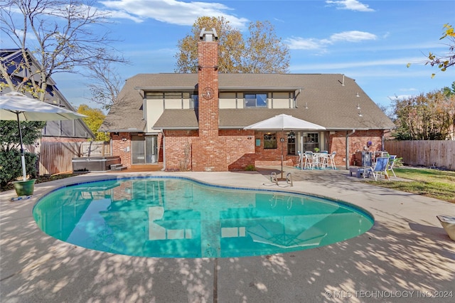 view of swimming pool with a hot tub and a patio