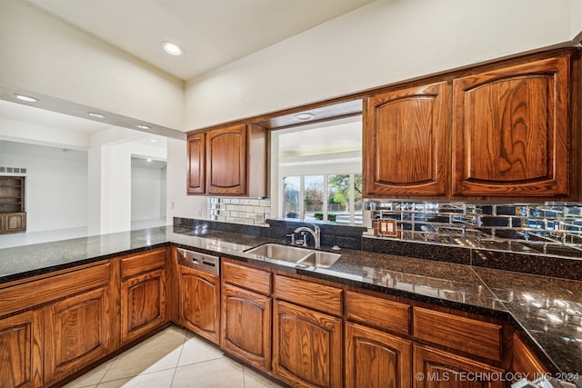 kitchen with tasteful backsplash, sink, paneled dishwasher, and light tile patterned floors