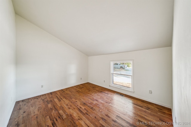 unfurnished room with vaulted ceiling and hardwood / wood-style flooring