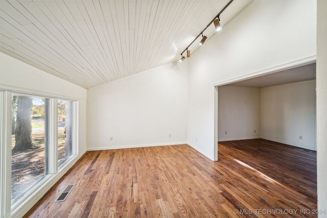 empty room with hardwood / wood-style floors, lofted ceiling, rail lighting, and wood ceiling