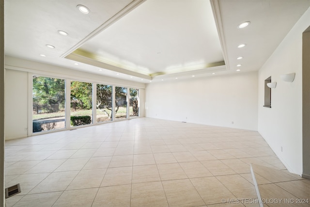 unfurnished living room featuring a raised ceiling and light tile patterned flooring