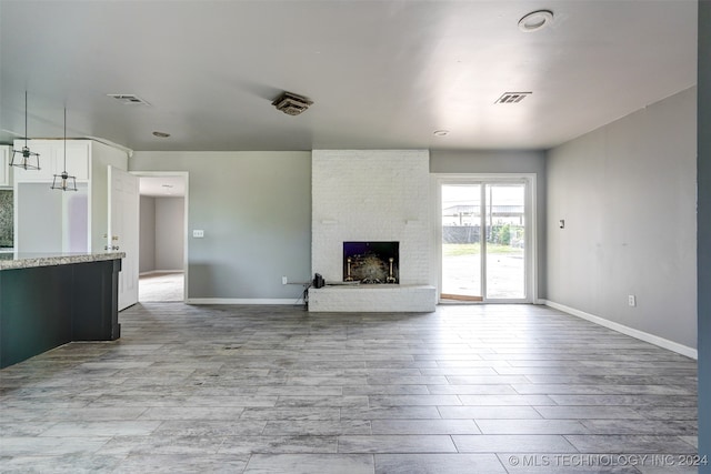 unfurnished living room with a fireplace and light hardwood / wood-style flooring