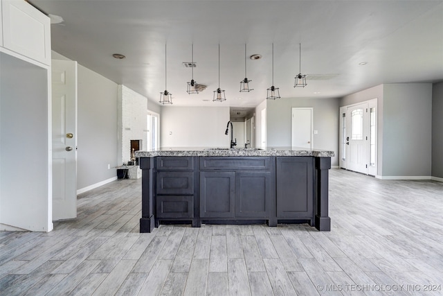 kitchen with light hardwood / wood-style flooring, hanging light fixtures, and plenty of natural light