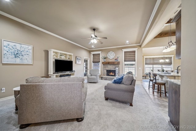 living room with a fireplace, ceiling fan with notable chandelier, carpet floors, and ornamental molding