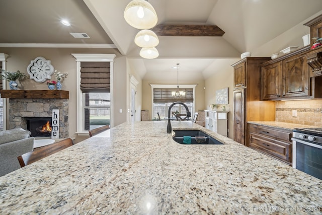 kitchen featuring decorative light fixtures, sink, a wealth of natural light, and tasteful backsplash