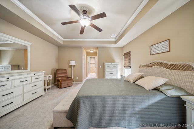 carpeted bedroom with ensuite bathroom, a raised ceiling, and ceiling fan