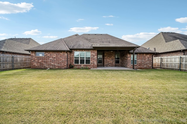 rear view of house with a lawn and a patio area