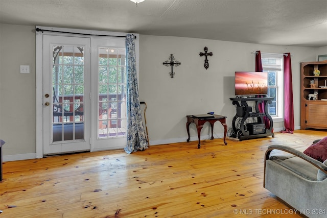 living room with a textured ceiling, hardwood / wood-style flooring, and plenty of natural light