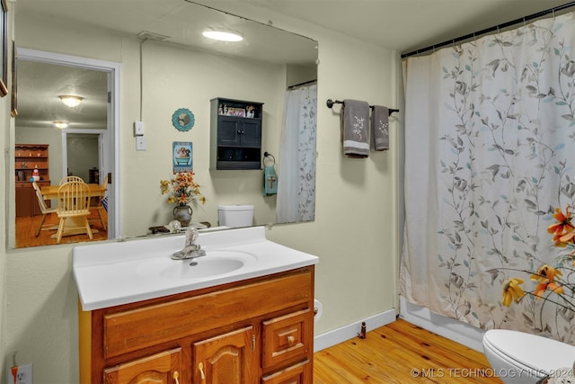 bathroom with vanity, toilet, and wood-type flooring