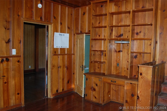 interior space featuring dark hardwood / wood-style flooring and wooden walls