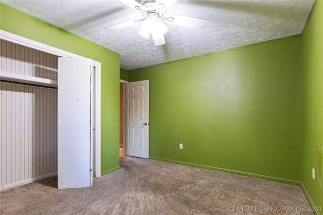 unfurnished bedroom featuring ceiling fan, carpet, and a textured ceiling