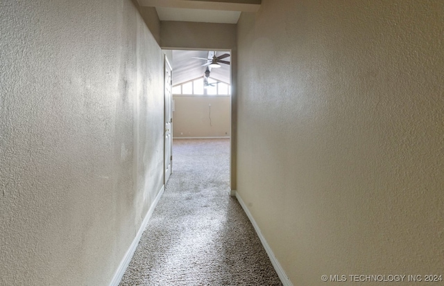 hall featuring lofted ceiling and light carpet