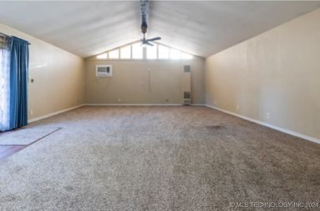 spare room with a wall mounted AC, vaulted ceiling with beams, carpet floors, and ceiling fan