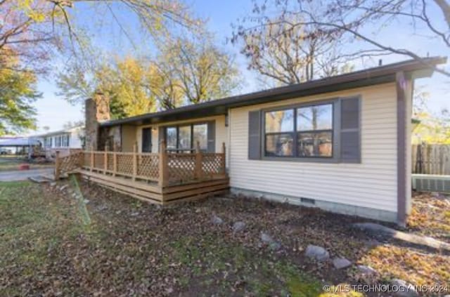 rear view of property featuring a wooden deck