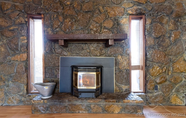 room details featuring hardwood / wood-style floors and a wood stove