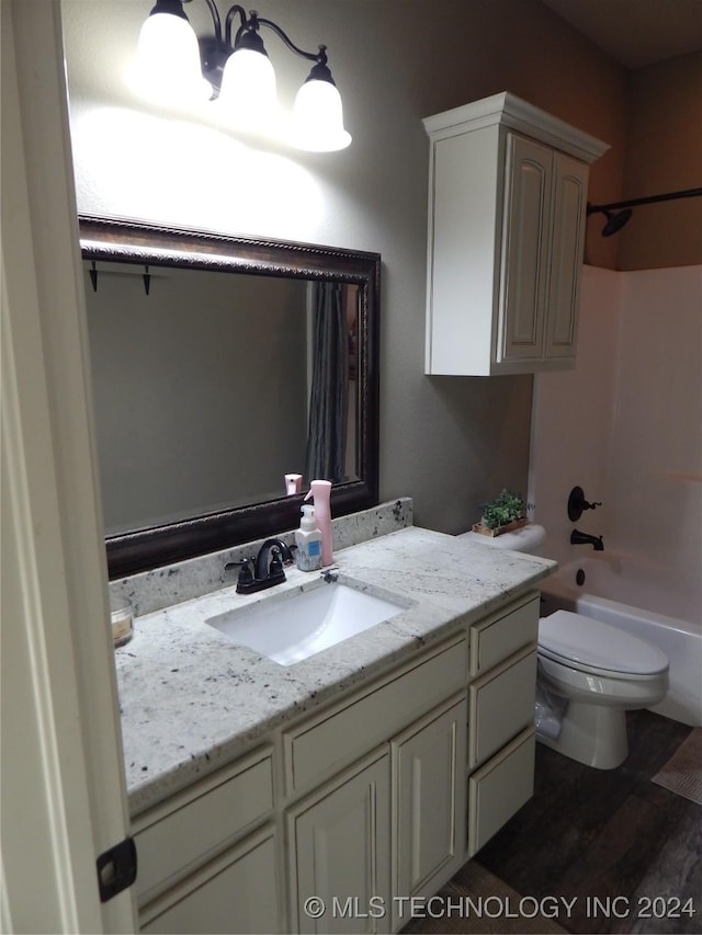 full bathroom with hardwood / wood-style flooring, vanity, shower / bath combination, and toilet