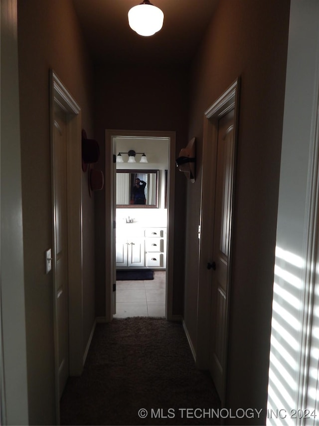 hallway featuring light colored carpet and sink