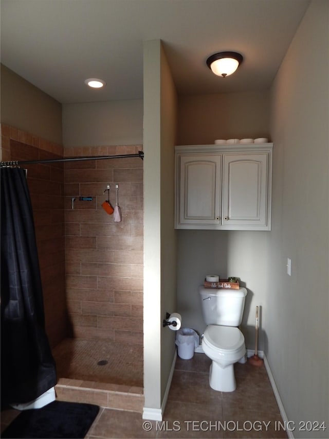 bathroom featuring toilet, a shower with curtain, and tile patterned floors