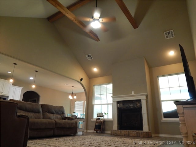 living room featuring a wealth of natural light, beamed ceiling, and high vaulted ceiling