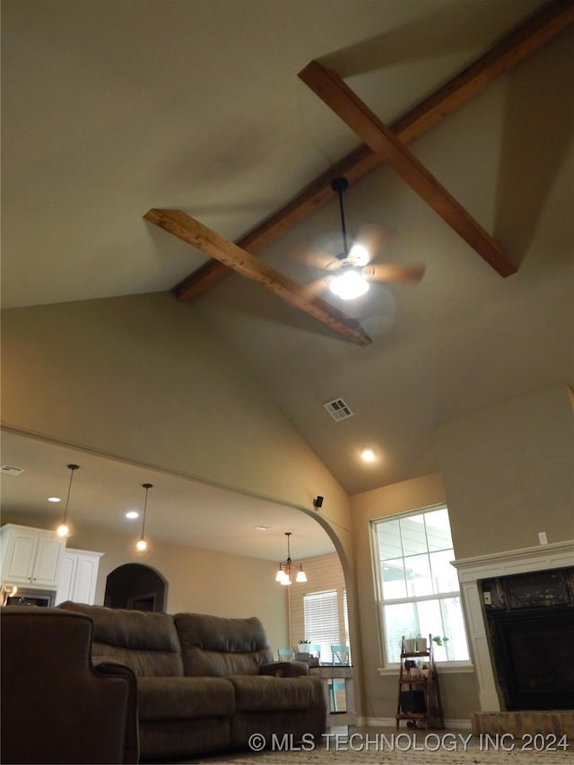 living room featuring ceiling fan with notable chandelier, beam ceiling, and high vaulted ceiling