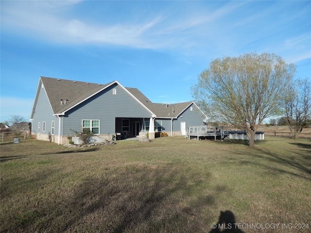 rear view of house featuring a yard and a wooden deck