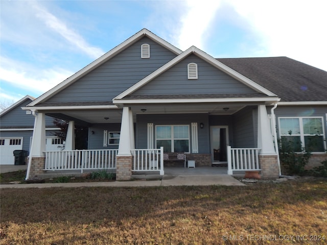 craftsman inspired home with a porch, a garage, and a front yard