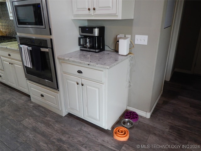 kitchen featuring white cabinets, appliances with stainless steel finishes, and dark hardwood / wood-style flooring