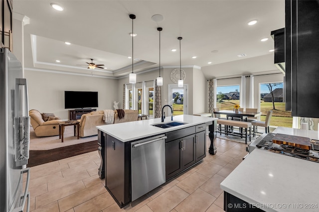 kitchen with sink, hanging light fixtures, an island with sink, light wood-type flooring, and appliances with stainless steel finishes