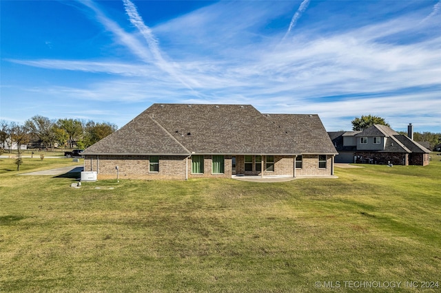 back of house featuring a lawn and a patio area