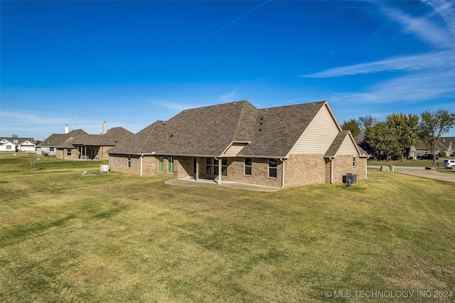 back of property with a lawn, cooling unit, and a patio