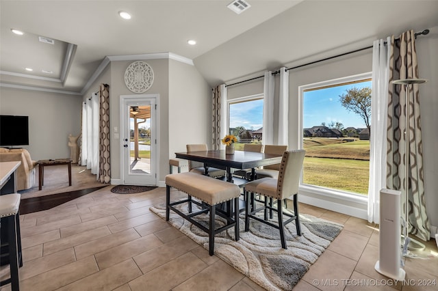 dining area featuring lofted ceiling, light hardwood / wood-style flooring, and crown molding