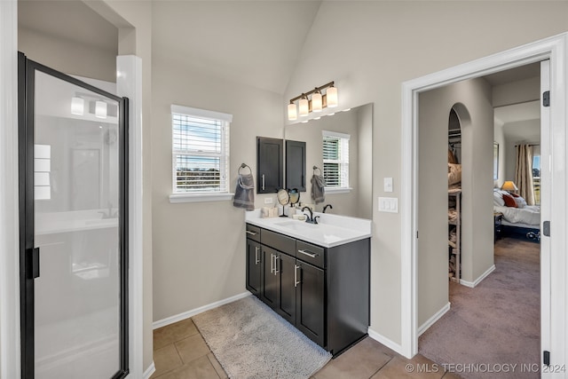 bathroom featuring a shower with door, tile patterned floors, plenty of natural light, and lofted ceiling