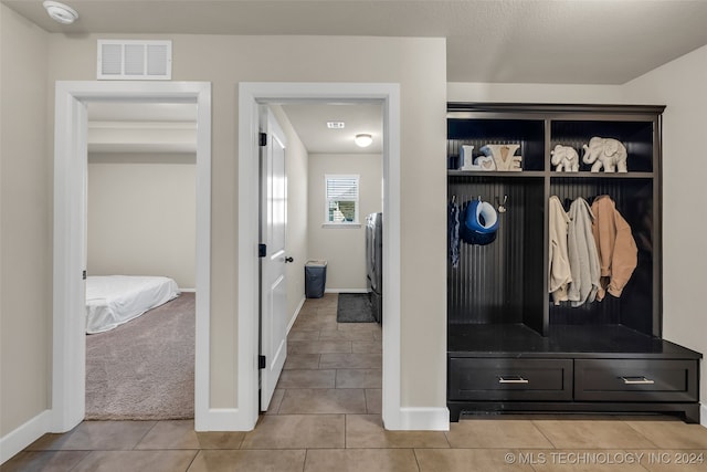 mudroom with light carpet and washer / dryer