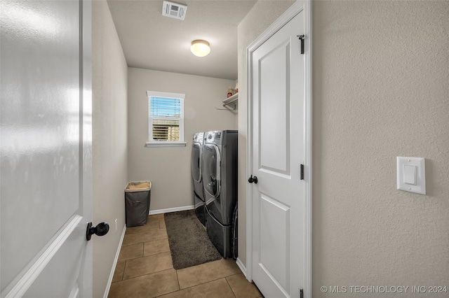 washroom with light tile patterned flooring and washing machine and clothes dryer