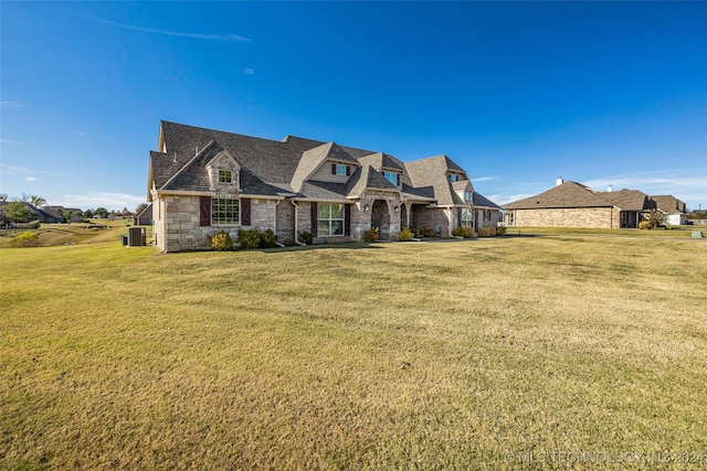 view of front of house with central AC and a front lawn