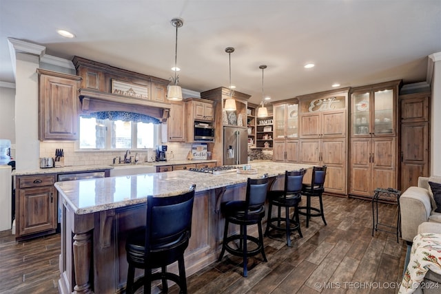 kitchen featuring appliances with stainless steel finishes, dark hardwood / wood-style flooring, hanging light fixtures, and a large island