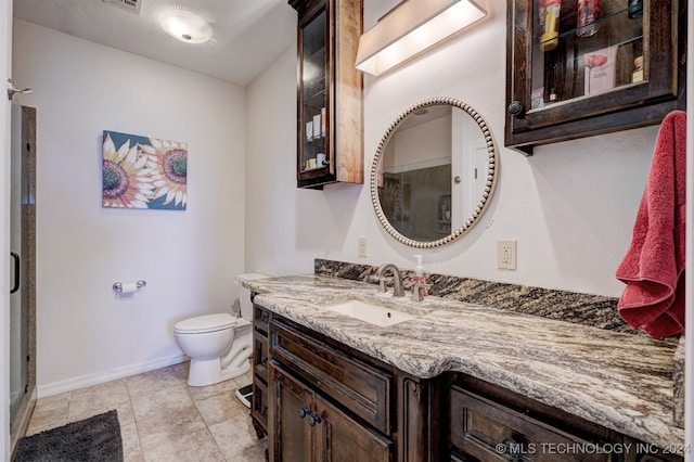 bathroom with tile patterned flooring, vanity, an enclosed shower, and toilet