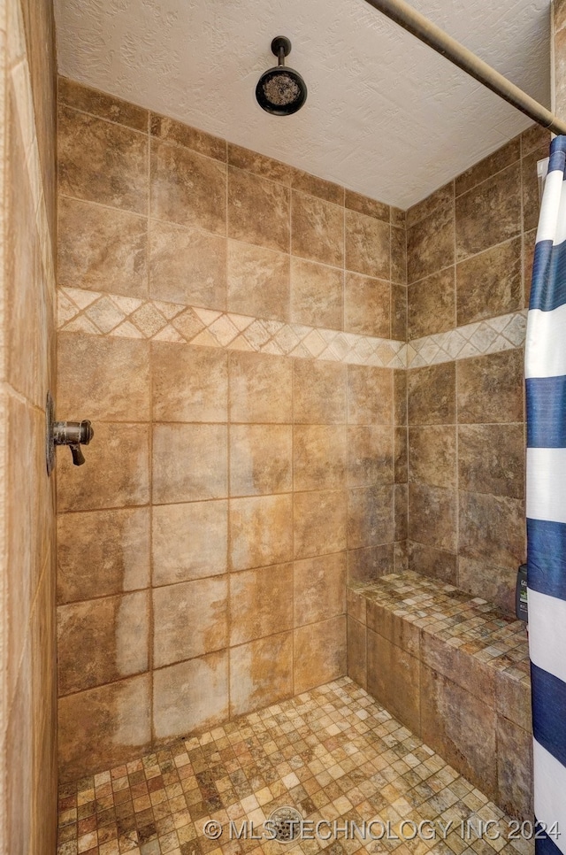 bathroom featuring a shower with curtain and a textured ceiling