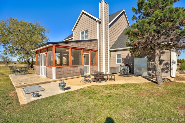 rear view of property with cooling unit, a fire pit, a patio area, a sunroom, and a lawn