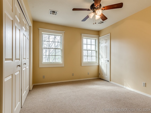 unfurnished bedroom featuring ceiling fan and light colored carpet