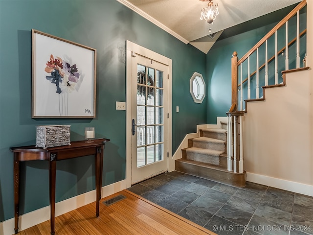 entryway with dark hardwood / wood-style floors, vaulted ceiling, and crown molding