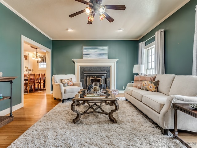 living room featuring light wood-type flooring, ceiling fan, and ornamental molding