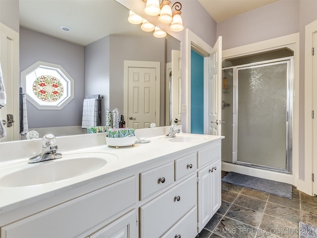 bathroom with vanity and a shower with door