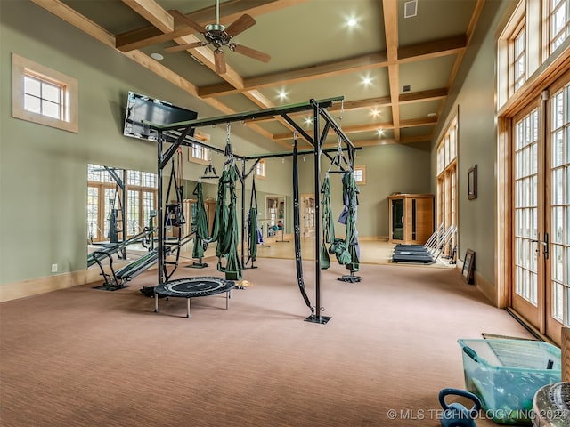 interior space featuring ceiling fan, french doors, coffered ceiling, a high ceiling, and light carpet