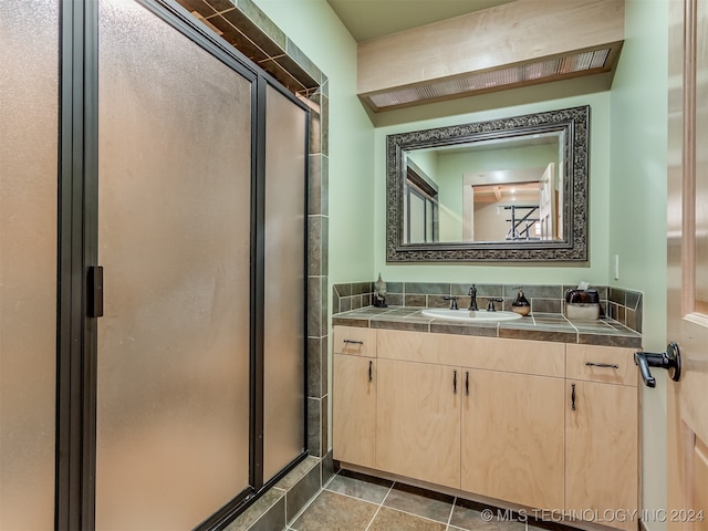 bathroom with tile patterned flooring, vanity, and a shower with door