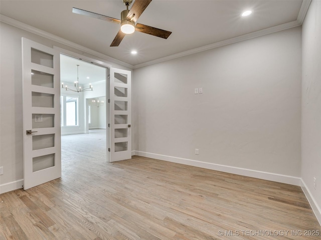 empty room featuring light wood-style floors, crown molding, ceiling fan with notable chandelier, and baseboards