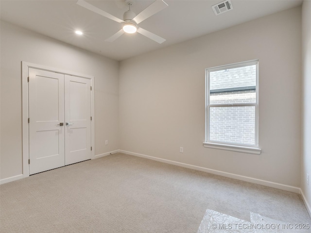 unfurnished room featuring baseboards, visible vents, and light carpet