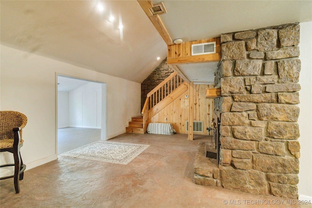 living room featuring wooden walls and lofted ceiling